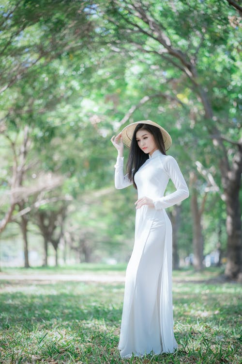 站在绿草地上的白色长袖连衣裙的女人 · 免费素材图片