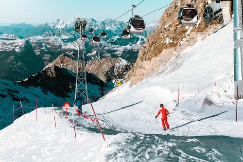 人们在白雪皑皑的高山滑雪的高角度视图 · 免费素材图片