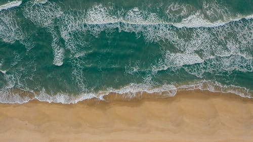 棕色沙滩上的水浪 · 免费素材图片