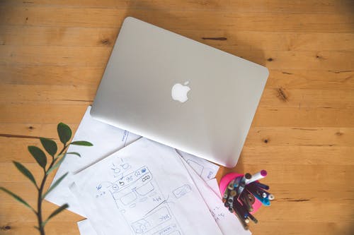 Macbook空气棕色木制的桌子上 · 免费素材图片