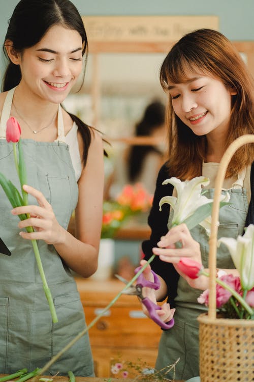 性格开朗的妇女，在商店里制作鲜花花束 · 免费素材图片