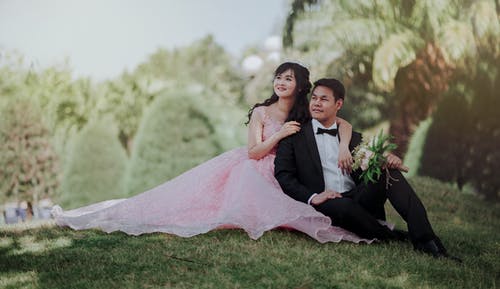 穿着黑色礼服的男人和穿着粉红色礼服的女人的结婚照 · 免费素材图片