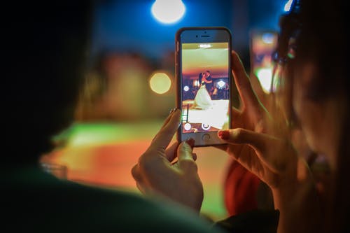 女人在晚上使用手机的特写镜头 · 免费素材图片