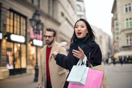 黑色外套拿着纸袋的女人 · 免费素材图片