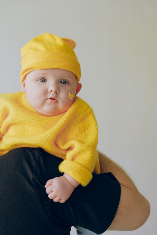 婴儿的黄色针织衫和黄色的针织帽 · 免费素材图片
