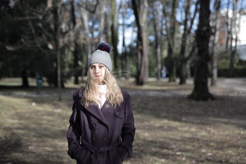 女人穿着帽子和紫大衣的浅焦点照片 · 免费素材图片
