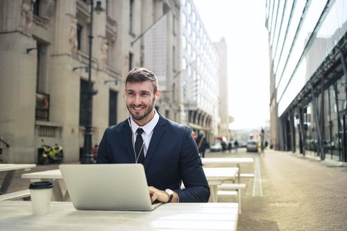 使用macbook的黑色西装外套的男人 · 免费素材图片