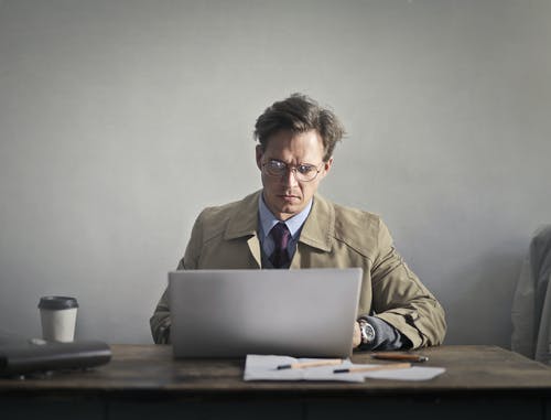 使用macbook的棕色西装外套的男人 · 免费素材图片