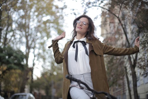 棕色西装外套骑自行车的女人 · 免费素材图片