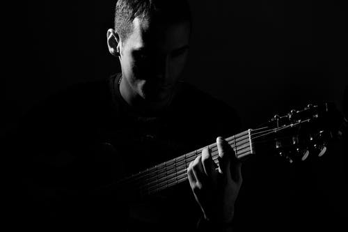 人弹吉他的灰度照片 · 免费素材图片