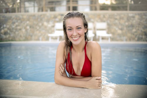 在游泳池里的红色比基尼上衣的女人 · 免费素材图片
