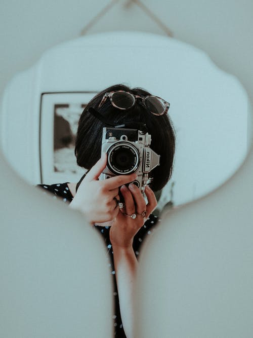 女人拿着黑色和银色尼康相机 · 免费素材图片