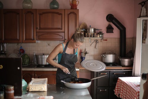 女人站在厨房的柜台附近 · 免费素材图片