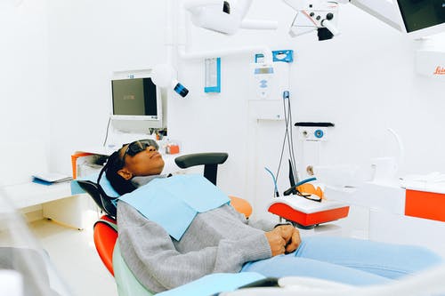 女人坐在牙科椅上 · 免费素材图片