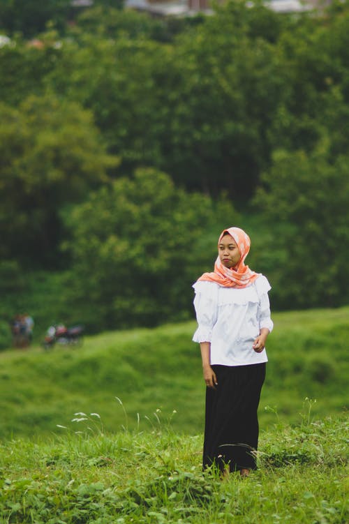白色长袖衬衫和黑色的裤子，站在草地上的女人 · 免费素材图片