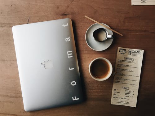 Macbook在茶杯附近的照片 · 免费素材图片
