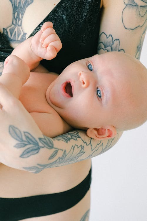 抱着婴儿的女人 · 免费素材图片