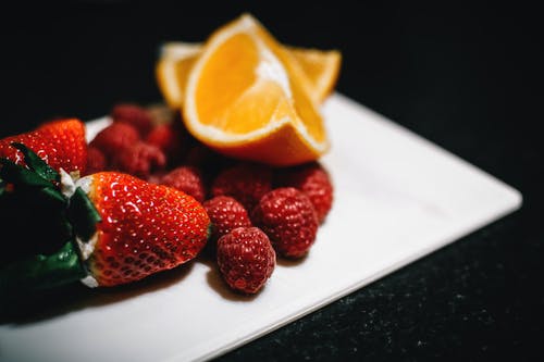 草莓和切成薄片的楔子橘子在白盘子里 · 免费素材图片