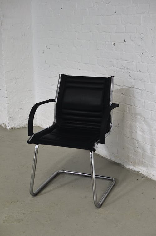 白墙旁的黑色和银色扶手椅 · 免费素材图片