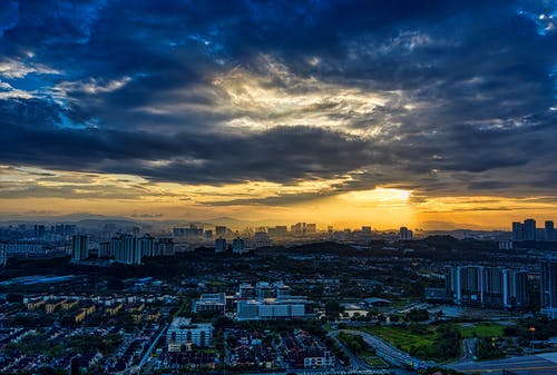 在日落期间多云的天空下的高层建筑的城市 · 免费素材图片