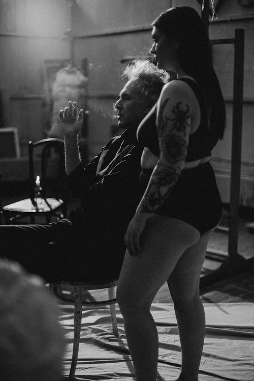 上衣和内衣站在男人抽烟的女人 · 免费素材图片