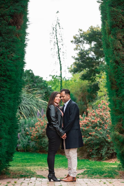 夫妇站在高树篱之间 · 免费素材图片