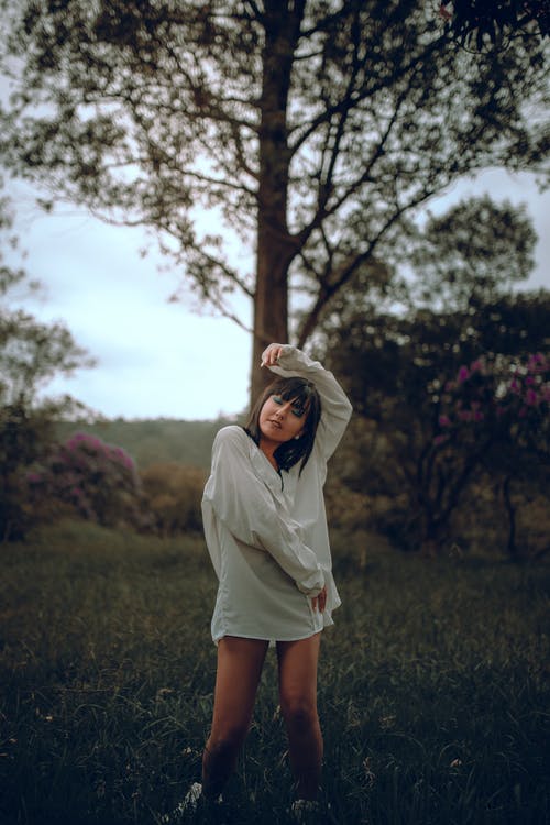 站在绿草地上的白色长袖衬衫的女人 · 免费素材图片