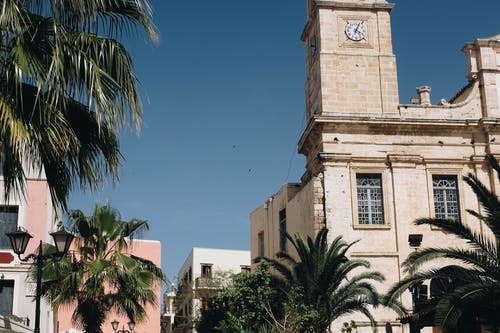 蓝蓝的天空下椰子树附近的高层建筑 · 免费素材图片