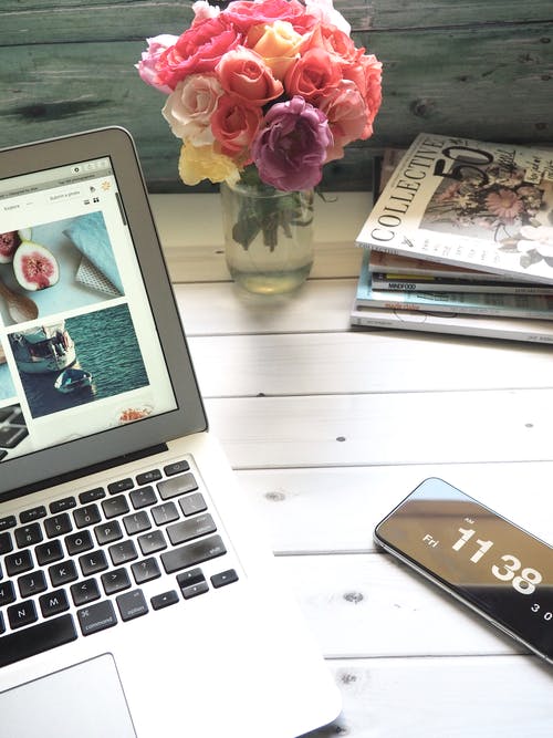 Macbook Air，花束和白色桌上的杂志 · 免费素材图片