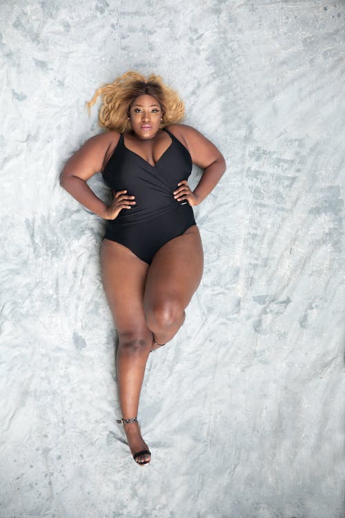 躺在地板上的黑色一件泳装的女人的开销照片 · 免费素材图片