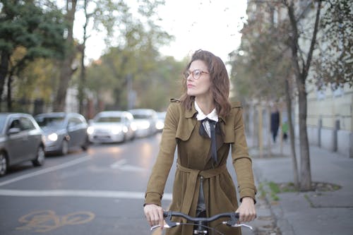 黑色的自行车，一个穿着棕色外套的女人开车 · 免费素材图片