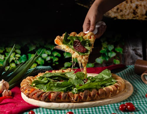 持有蔬菜披萨的人 · 免费素材图片