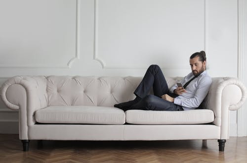 男子坐在沙发上的照片 · 免费素材图片