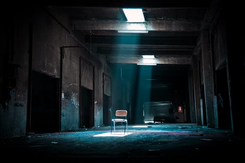 从外面来的聚光灯在被遗弃的地方上的椅子 · 免费素材图片