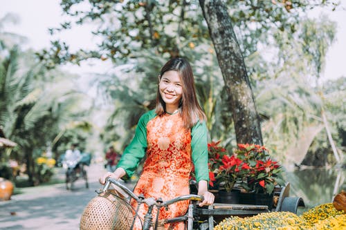 绿色长袖衬衫骑自行车的女人 · 免费素材图片