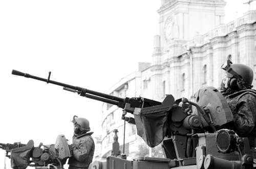 男子手持步枪的灰度照片 · 免费素材图片