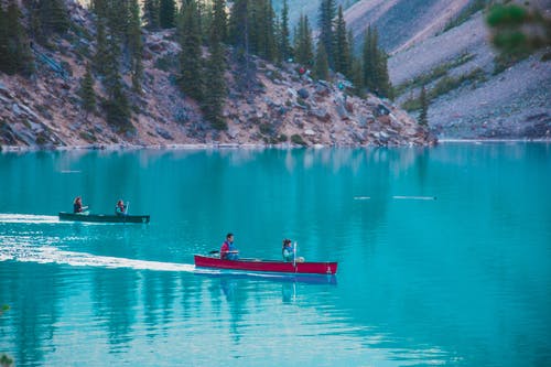 人骑在湖上的红色皮划艇 · 免费素材图片