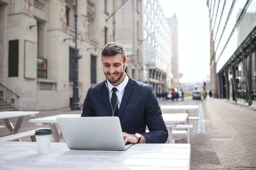 使用macbook的黑色西装外套的男人 · 免费素材图片