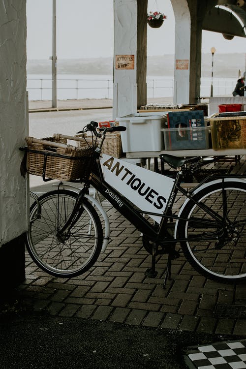 黑城自行车停在白墙旁边 · 免费素材图片