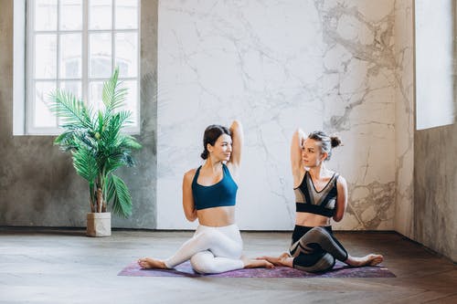 2名妇女坐在galaxy Design瑜伽垫上 · 免费素材图片