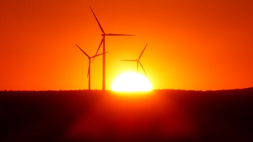 风力涡轮机在日落时的剪影 · 免费素材图片