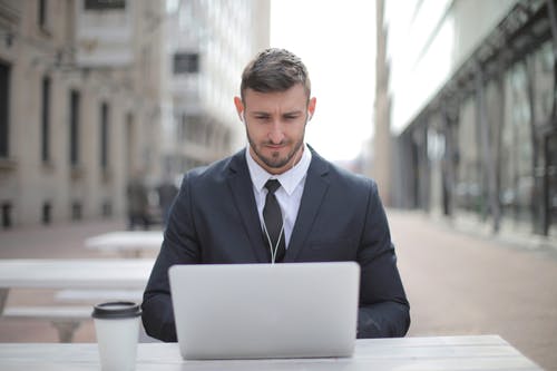 使用macbook的黑色西装外套的男人 · 免费素材图片