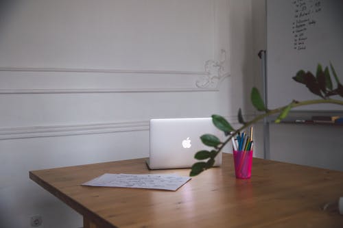笔记本电脑和桌上的笔粉红色杯 · 免费素材图片