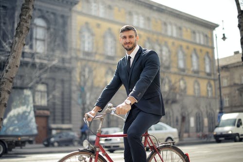 黑色西装外套和黑色的裤子，骑一辆红色自行车的人 · 免费素材图片