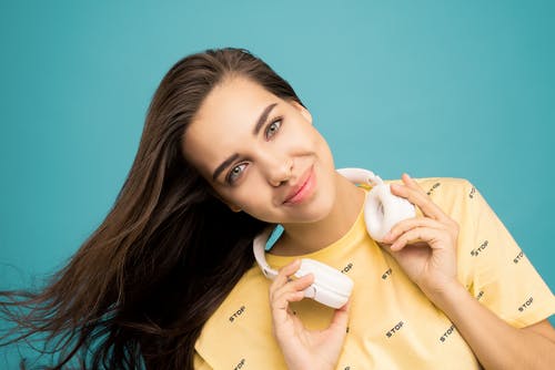 女人抱着耳机的特写照片 · 免费素材图片