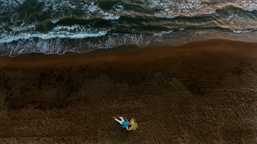 情侣躺在海边的航拍照片 · 免费素材图片