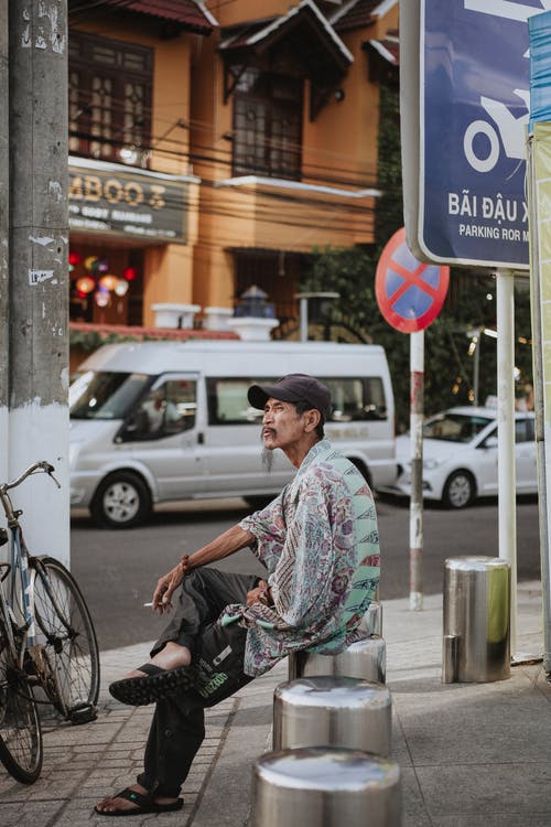 坐在户外吸烟的人 · 免费素材图片