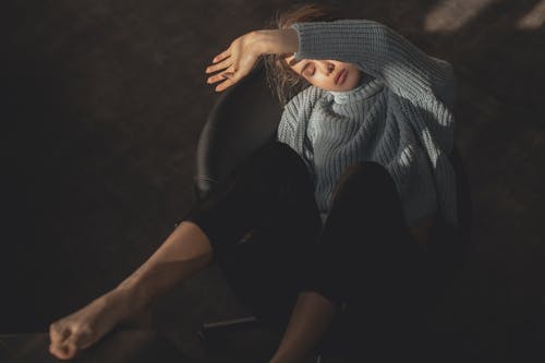 灰色针织毛衣和黑色的裤子，坐在黑色的皮椅上的女人 · 免费素材图片