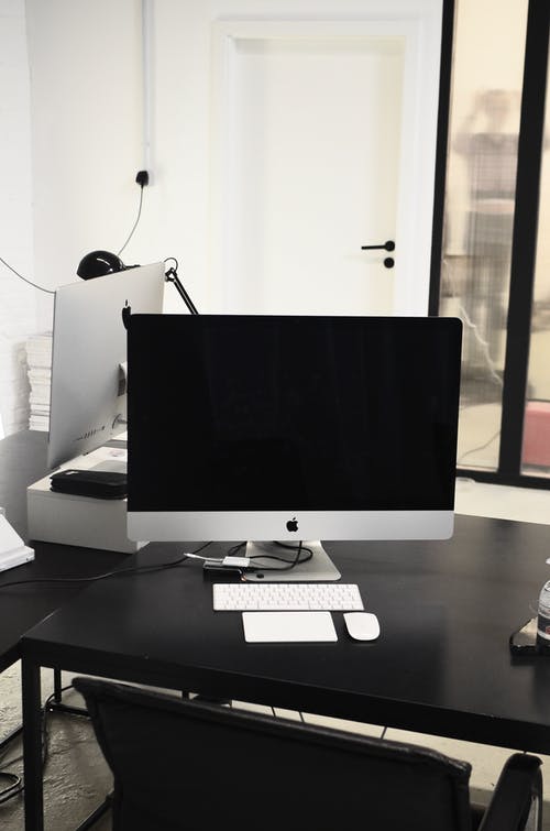 黑色的木桌上的银imac · 免费素材图片