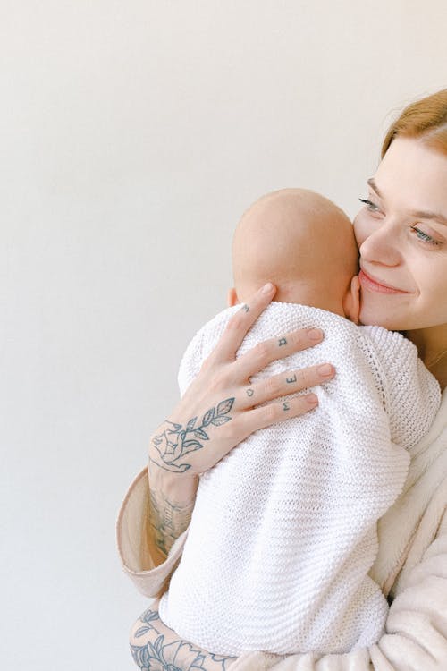 米色毛衣婴儿的女人 · 免费素材图片